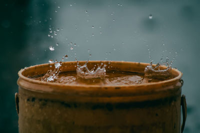 Rain water drop falling to the pail in heavy rain day