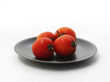 Close-up of fruits in plate against white background