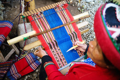 High angle view of woman weaving cloth