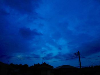 Low angle view of silhouette electricity pylon against sky at dusk