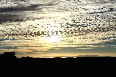 Silhouette landscape against sky at sunset