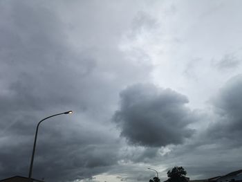 Low angle view of street light against cloudy sky