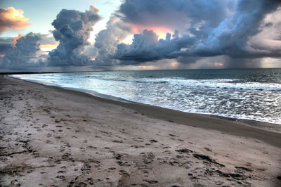 Scenic view of beach against sky during sunset