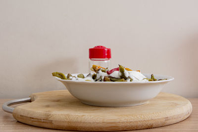 Close-up of dessert in bowl on table against wall