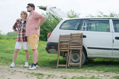 Rear view of couple walking on field