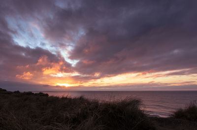 Scenic view of sea against cloudy sky