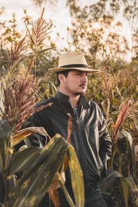 Thoughtful man standing amidst plants