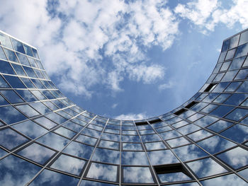 Low angle view of modern building against cloudy sky