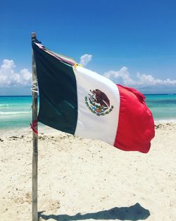 Flag on beach against sky