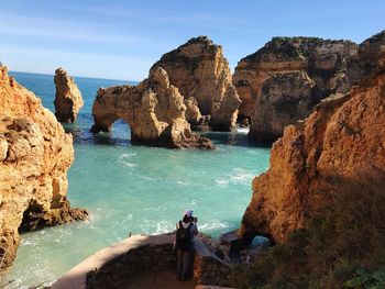 High angle view of woman standing on observation point by sea at ponta da piedade