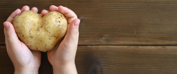 Cropped image of hand holding heart shape on table