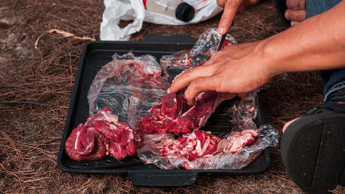 A man cutting steak on a cutting board at evening