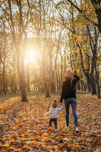 Family fall social distancing activities. happy family mom and toddler baby girl playing outdoors