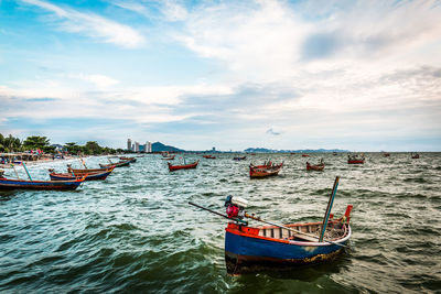 Boats moored on sea against sky