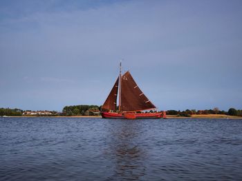 Sailboat sailing on sea against sky