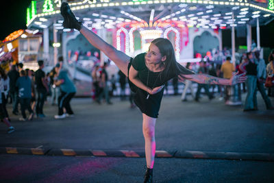 Full length of woman with arms raised in city