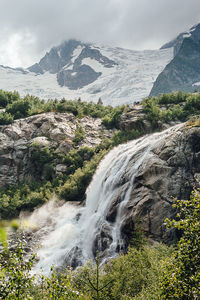 Scenic view of waterfall against sky