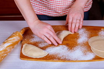 Cropped hands of woman preparing food on cutting board