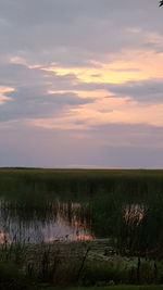 Scenic view of river against cloudy sky