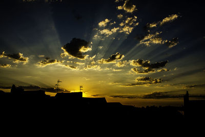 Low angle view of silhouette building against dramatic sky