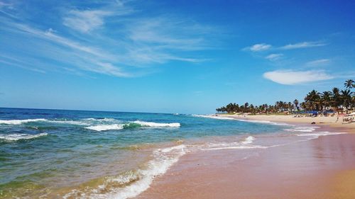 Scenic view of beach against blue sky