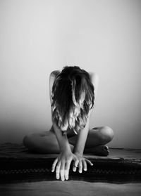 Woman sitting on wall at home