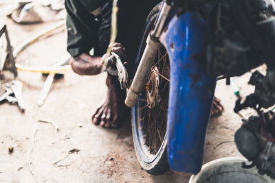 Low section of mechanic repairing motorcycle in garage