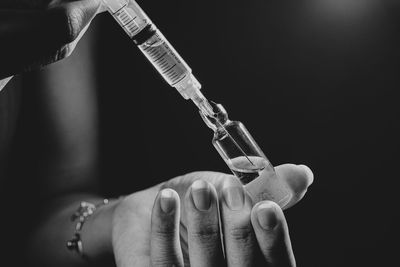 Close-up of hand holding syringe