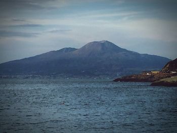 Scenic view of sea and mountains against sky