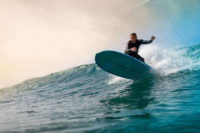 Man surfing on sea against sky