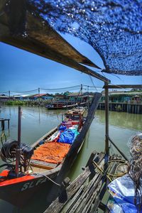 Boats moored in river against sky