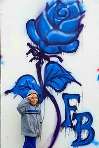 Young woman standing against graffiti wall