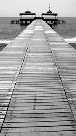 Wooden jetty on pier at sea against sky