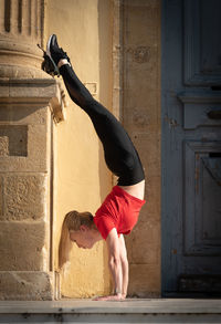 Full length of woman standing against wall