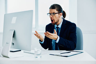 Young man using mobile phone in office