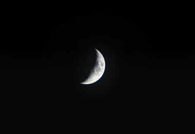 Low angle view of half moon against sky at night