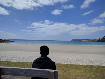 Rear view of man sitting on beach