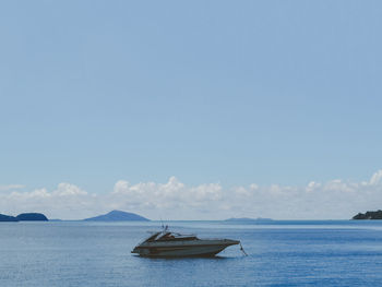 Sailboats moored on sea against sky