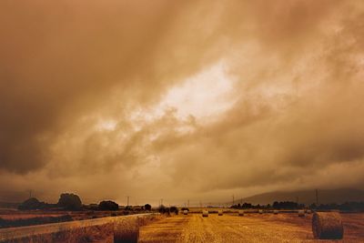 Scenic view of field against storm clouds