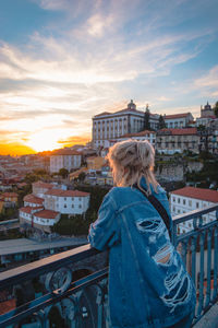 Woman standing by railing against buildings in city