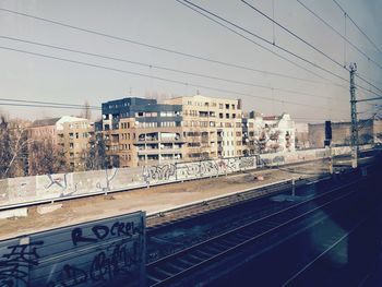 Railroad tracks in city against clear sky