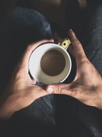 Directly above shot of hand holding coffee cup