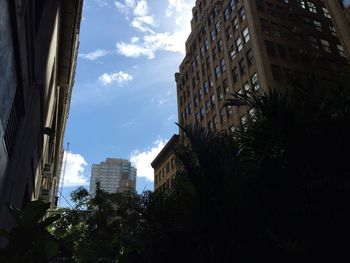 Buildings in city against cloudy sky