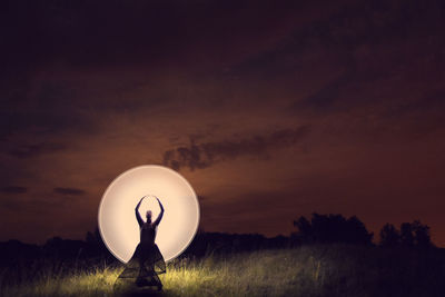 Silhouette person standing on field against sky during sunset