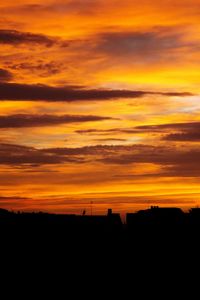 Scenic view of silhouette landscape against orange sky