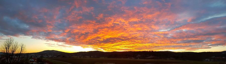 Scenic view of dramatic sky over silhouette landscape