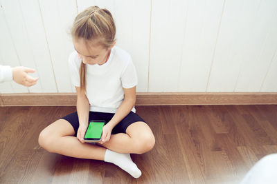 High angle view of boy playing with toy on hardwood floor at home