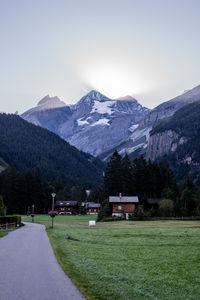 Scenic view of field by mountains against sky