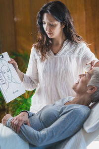 Masseur showing book to woman at spa