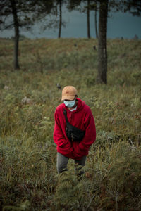 Man wearing mask walking on grassland